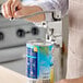 A manual can opener being used to open a large can on a kitchen counter.