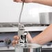 A person using a Choice Prep Standard Duty manual can opener to open a metal can on a counter.