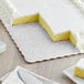 A close up of a white cake on a silver Enjay double wall cake board.