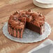 A chocolate cake on a silver Enjay cake circle with chocolate chips.