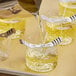 A counter with Acopa glass votive candle holders filled with liquid.