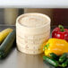 A Town bamboo steamer set filled with vegetables on a counter.