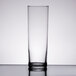 A Libbey straight sided glass filled with a clear liquid on a table.