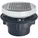 A Zurn floor drain with a square metal strainer with a white circle around it and a black base.