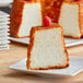 A piece of Pillsbury Bakers' Plus Angel Food Cake with a raspberry on top.
