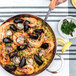 A de Buyer paella pan filled with seafood rice and shrimp.