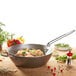A de Buyer carbon steel stir fry pan with shrimp, rice, and vegetables.