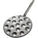 A de Buyer carbon steel pan with round holes in it.