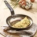 A de Buyer carbon steel omelette pan with an omelette in it.