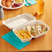 A white container with EcoChoice Natural Bagasse 2-compartment take-out container with food in it.