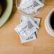 A cup of coffee next to a Cafe Delight non-dairy creamer packet on a table.