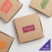 Three brown Choice pizza boxes with a purple logo.