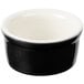 A close up of a black and white Tuxton ramekin with a white rim.