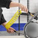 A person using an Assure Parts yellow coiled air/water hose.