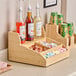 A Cal-Mil bamboo condiment organizer on a hotel buffet counter.