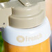 A Tablecraft white plastic collar with beige lettering sitting on a bottle of liquid.
