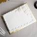 A white cake on a gold Enjay quarter sheet cake board.