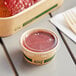 A container of food with a EcoChoice PLA lid on a table.