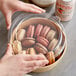 A container of macarons with a Choice round PET lid on a table.