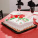 A white rectangular sheet cake on a gold laminated cake pad on a table.