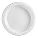 A close-up of a white Huhtamaki Chinet plastic plate with a decorative edge.