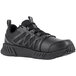 A black Reebok men's athletic shoe with a soft toe, non-slip sole, and mesh and synthetic upper, designed for work environments.