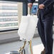 A person in blue overalls uses a Lavex solution tank on a floor cleaning machine.