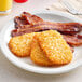 A plate of hash browns and bacon on a table.