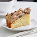 A slice of Hahn's Bakery Chocolate German Crumb Cake on a plate with a fork next to a cup of coffee.