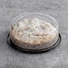 A Hahn's Bakery cinnamon crumb cake in a plastic container on a table in a bakery display.