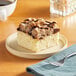 A piece of Hahn's Bakery chocolate German crumb cake on a plate with a fork next to a cup of coffee.