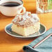 A piece of Hahn's Bakery Traditional Cinnamon German Crumb Cake on a plate next to a cup of coffee.