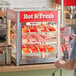 A man standing at a ServIt countertop display with food in it.