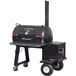 A black Meadow Creek TS70P barbecue smoker on wheels with a red handle.