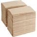 A stack of Tork natural kraft interfold dispenser napkins.