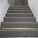 A set of stairs with black and yellow striped safety tape.