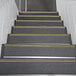 A set of stairs with black and yellow striped safety treads.