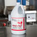 A white jug with red label of Noble Chemical Knockout on a counter.