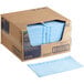 A case of blue Tork paper towels on a table.