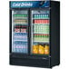 A Turbo Air TGM-47SDB-N glass door refrigerator full of drinks including a yellow jug.