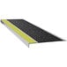 A black Wooster Flexmaster stair tread with yellow stripes and a yellow grit surface.