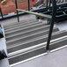 A set of Wooster Flexmaster stair treads with marine black grit surface on metal railings.