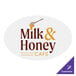 A white oval Carnival King vinyl floor decal with brown text reading "Milk and Honey Cafe"