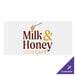 A white rectangular Carnival King vinyl magnet with brown text that says "milk and honey cafe"