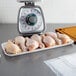 A white CKF foam tray holding raw chicken legs on a kitchen counter.