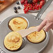 A person using a de Buyer beechwood crepe spatula to flip a pancake.