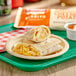 An El Monterey breakfast burrito with egg, sausage, potato, and cheese on a plate.