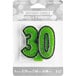 A package of green glitter "30" candles with a green number 30 candle.