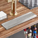 A Regency stainless steel surface-mount beer drip tray on a bar counter.