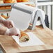 A person wearing plastic gloves uses Choice wet wax paper to cut a sandwich.